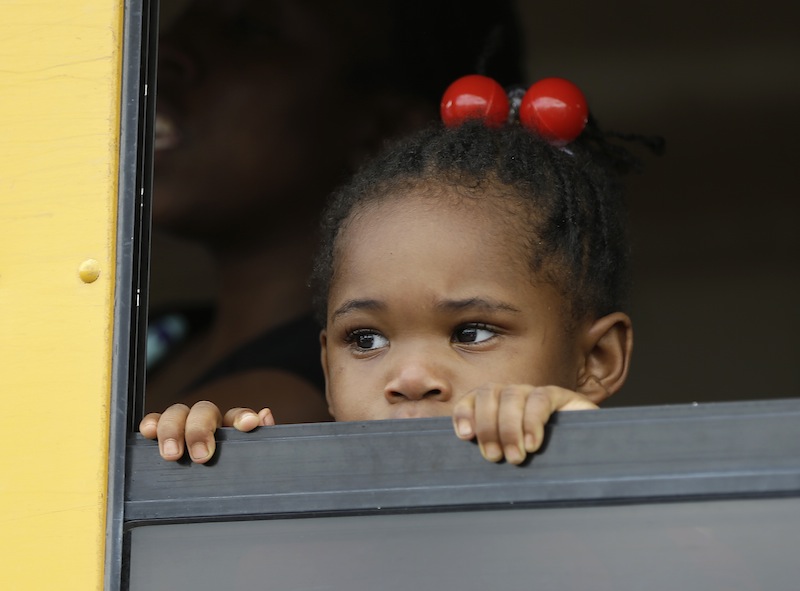 A child peers out the window of a school bus as busses arrive with students after an incident at Ronald McNair Discovery Learning Academy, Tuesday, Aug. 20, 2013 in Decatur, Ga. Superintendent Michael Thurmond says all students at Ronald E. McNair Discovery Learning Academy in Decatur east of Atlanta are accounted for and safe Tuesday and that he is not aware of any injuries. (AP Photo/John Bazemore)
