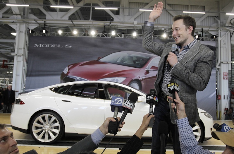 In this June 22, 2012 file photo, Tesla CEO Elon Musk waves during a rally at the Tesla factory in Fremont, Calif. Musk on Monday, Aug. 12, 2013 unveiled a concept for a transport system he says would make the nearly 400-mile trip in half the time it takes an airplane. The "Hyperloop" system would use a large tube. Inside, capsules would float on air, traveling at over 700 miles per hour. (AP Photo/Paul Sakuma, File)