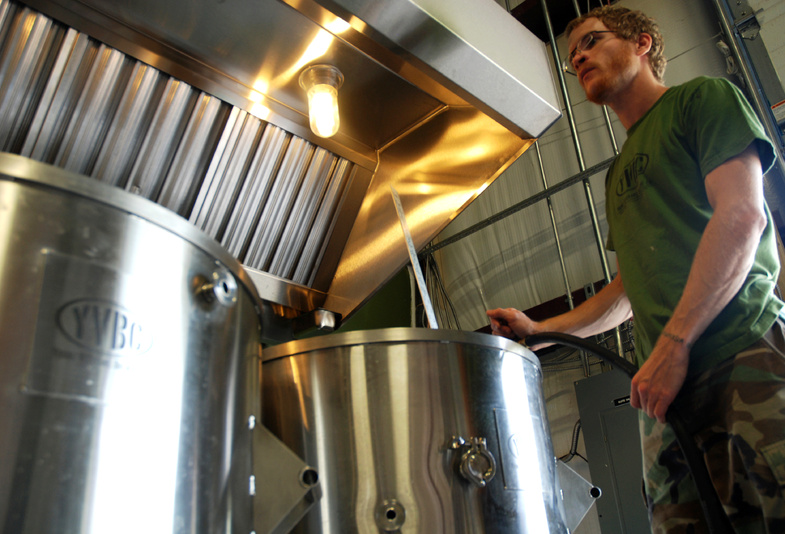 Neil McCanon, an Iraq War veteran and head brewer at Young Veterans Brewing Co., adds water to the brew kettle as he prepares to brew Pineapple Grenade Hefeweizen at the Virginia Beach, Va., brewery.