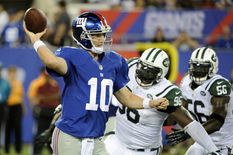 New York Giants quarterback Eli Manning (10) throws a pass away from New York Jets defensive end Muhammad Wilkerson (96) and Ricky Sapp (55) during the first half of a preseason NFL football game, Saturday, Aug. 24, 2013, in East Rutherford, N.J. (AP Photo/Bill Kostroun)
