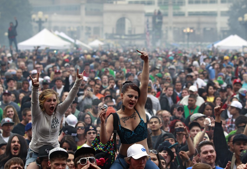 In this April 20, 2013 file photo, members of a crowd numbering tens of thousands smoke marijuana and listen to live music, at the Denver 420 pro-marijuana rally at Civic Center Park in Denver. The U.S. government said Thursday, Aug. 29, 2013 that the federal government will not make it a priority to block marijuana legalization in Colorado or Washington or close down recreational marijuana stores, so long as the stores abide by state regulations. (AP Photo/Brennan Linsley, File)