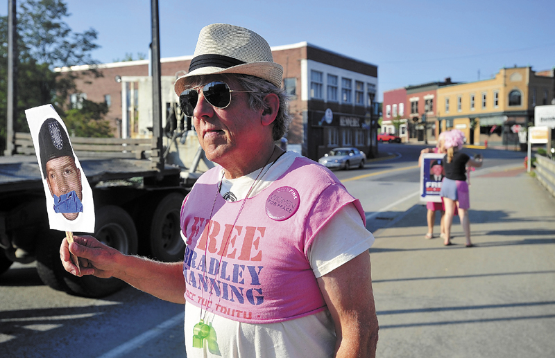 Mark Roman, 65, of Solon, stands on the Margaret Chase Smith Bridge in downtown Skowhegan with a picture of Bradley Manning on Wednesday. Roman and four other individuals stood on the bridge with signs to protest the Court Martial of former army enlisted man, Bradley Manning, for leaking documents to Wikileaks.
