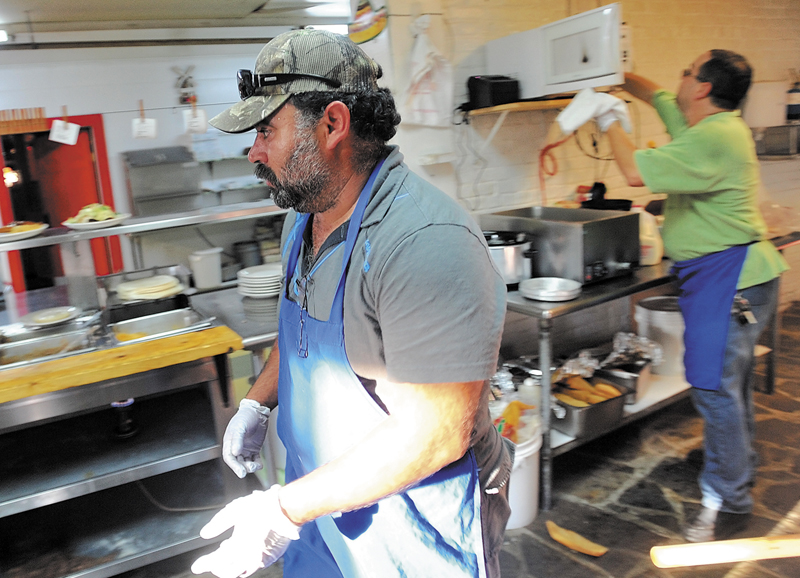 This October 2011 file photo shows Myao Perez, center, in the kitchen at Cancun Restaurant in Waterville as Hector Fuentes, back right prepares food in the background. Perez volunteered to help Fuentes keep his business open after several workers were arrested for charges of illegal immigration.