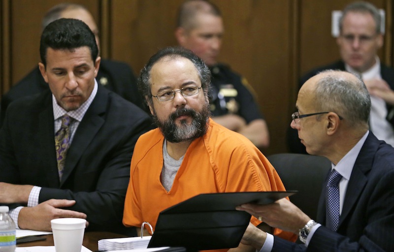 Ariel Castro, center, listens in the courtroom during the sentencing phase Thursday, Aug. 1, 2013, in Cleveland. Defense attorney's Craig Weintraub, left, and Jaye Schlachet sit beside Castro. Three months after an Ohio woman kicked out part of a door to end nearly a decade of captivity, Castro, a onetime school bus driver faces sentencing for kidnapping three women and subjecting them to years of sexual and physical abuse. (AP Photo/Tony Dejak)