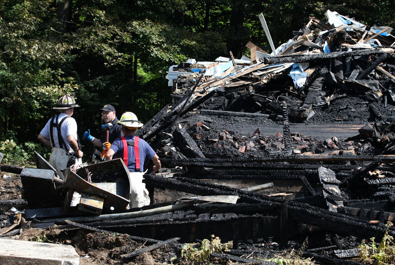 North Yarmouth Fire Chief Ricky Plummer, left, and Deputy Fire Chief Harold Stoddard, right, speak with State Fire Marshal Senior Chief Investigator Chris Stanford, center, looks through the remains of the Wescustogo Grange Hall that was destroyed by fire Friday, Aug. 30, 2013 in North Yarmouth.