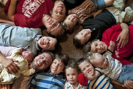 The 12 Schwandt brothers pose for a photo in their home in Rockford, Mich. Clockwise from bottom left are, Tyler, 21, holding Tucker, 2 days, Vinny, 10, Drew, 16, Zach, 17, Charlie, 3, Calvin, 8, Brandon, 14, Luke, 19 months, Gabe, 6, Wesley, 5 and Tommy, 11.
