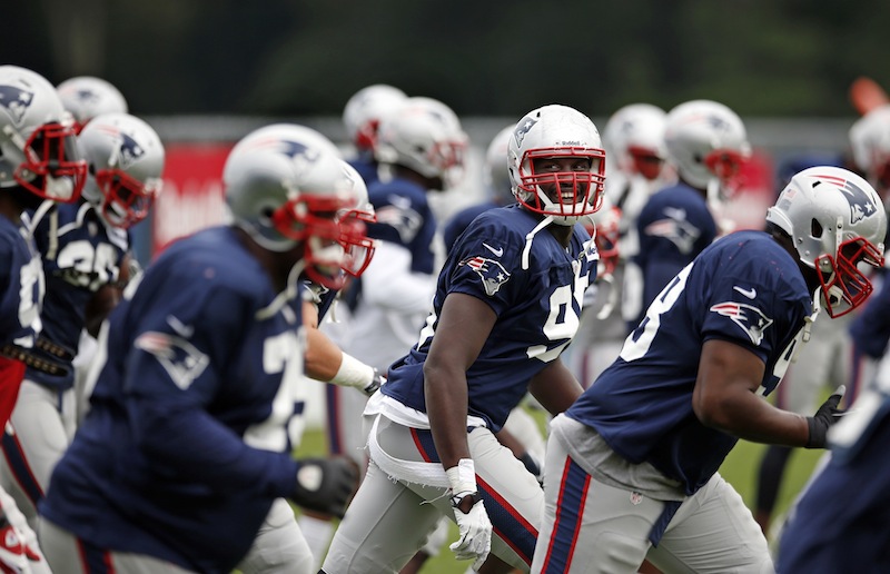 New England Patriots defensive end Chandler Jones laughs with teammates as they jog during team football practice in Foxborough, Mass., Monday, Aug. 26, 2013. (AP Photo/Elise Amendola)