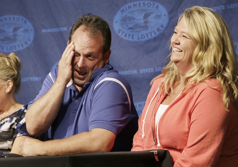 Paul White, of Ham Lake, Minn. gets a laugh from his girlfriend Kim VanRees, right, as he talked about his plans after he was announced as one of the winners of the $448.4 million Powerball Jackpot, Thursday, Aug. 8, 2013 in Minneapolis. White's share of the jackpot is $149.4 million. The woman at left is a co-worker friend. (AP Photo/Jim Mone)
