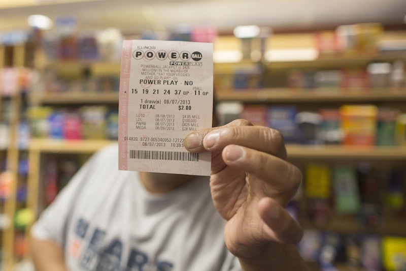 A man holds up his Powerball ticket inside of a convenience store in Chicago on Wednesday.