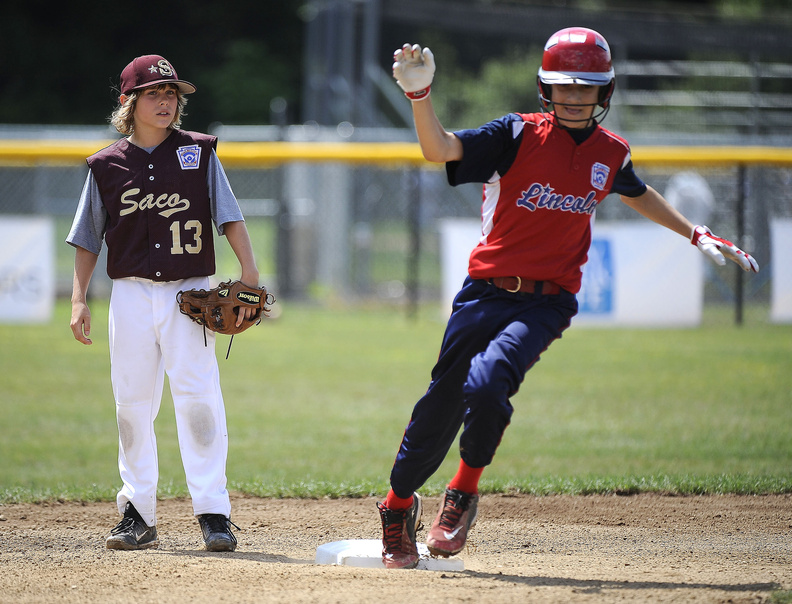 Aaron DeSouza of Lincoln, R.I., rounds second base and heads toward third as Saco’s Timmy Smith looks on during Lincoln’s 11-2 win Friday at the Little League New England Regional.