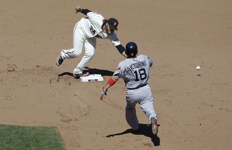 San Francisco Giants shortstop Brandon Crawford cannot catch the ball after a throwing error by San Francisco Giants pitcher Michael Kickham as Boston Red Sox's Shane Victorino (18) runs toward second base during the eighth inning in San Francisco on Wednesday.