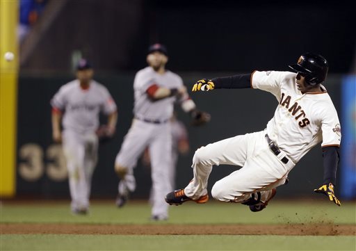San Francisco Giants' Joaquin Arias slides into third base with an RBI triple against the Boston Red Sox during the fifth inning of Tuesday's game. The Giants won, 3-2.