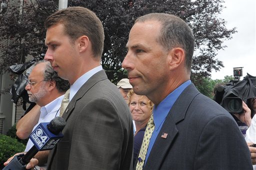 Massachusetts State Police Sgt. Sean Murphy, right, a tactical photographer, and his son Connor Patrick Murphy, arrive at State Police Headquarters in Framingham for his hearing to determine his duty status after he released images of the arrest of the Boston Marathon bombing suspect in this July 23, 2013, photo.