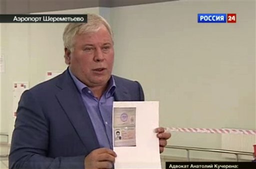 In this image taken form Russia24 TV channel, Russian lawyer Anatoly Kucherena shows a temporary document to allow Edward Snowden cross the border into Russia.