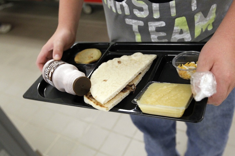 In this Wednesday, Sept. 12, 2012 file photo, a student at Eastside Elementary School in Clinton, Miss., holds a school lunch served under federal standards, consisting of a flatbread roast beef sandwich, apple sauce, chocolate milk and a cookie. After just one year, some schools across the nation are dropping out of what was touted as a healthier federal lunch program, complaining that so many students refused the meals packed with whole grains, fruits and vegetables that their cafeterias were losing money. (AP Photo/Rogelio V. Solis, File)
