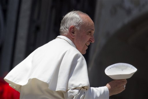 Pope Francis holds his skull-cap as he leaves at the end of his weekly general audience in St. Peter's Square, at the Vatican, in this May 29, 2013, photo.