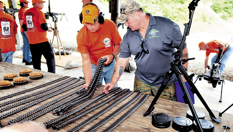 Andy Williams, right, and a volunteer load automatic weapons with live ammunition belts during the Wounded Warrior Machine Gun Shoot in North Anson on Sunday.