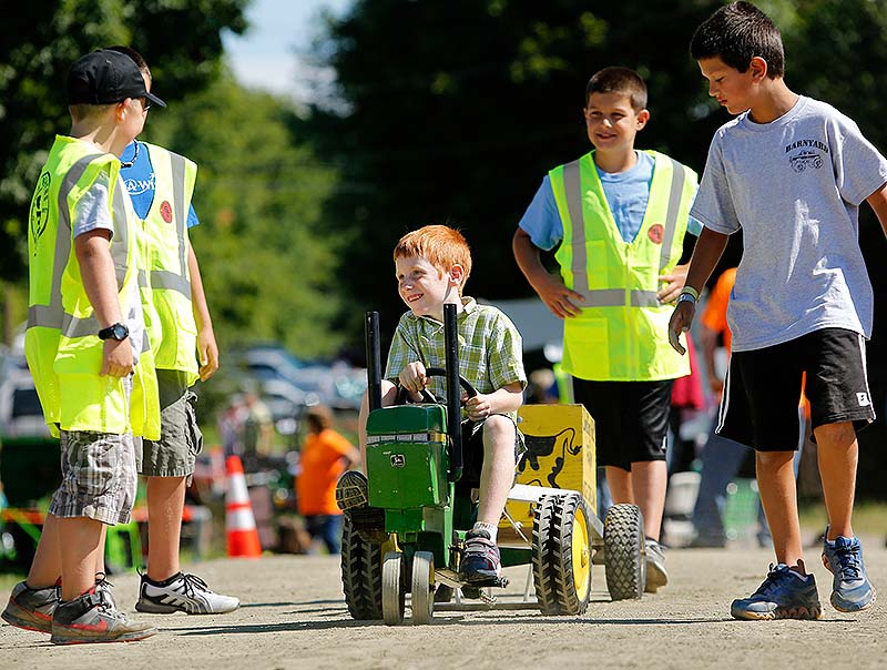 Owen WInslow of Auburn, who had brain surgery nine weeks ago, pedals a tractor as the Southern Maine Garden Tractor Pulling Club holds its 6th annual fundraiser for the Make-A-Wish Foundation in Saco on Sunday.