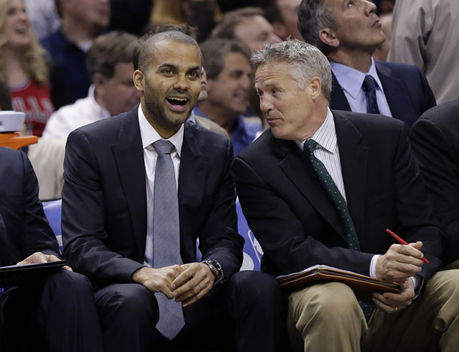 In this March 6, 2013, photo, San Antonio Spurs' assistant coach Brett Brown, right, sits with injured Spurs player Tony Parker during an NBA game.