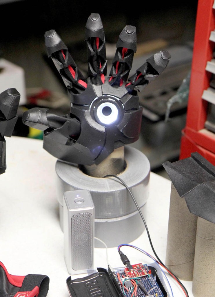 A hand with a bionic repulsor lights up in Thomas Lemieux's workshop, in the basement of his Oakland home, recently.