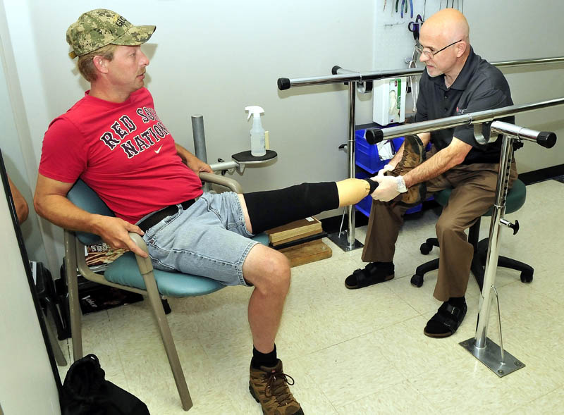 Prosthetist Kevin Carroll, right, evaluates the prosthetic device worn by Ronald McLaggan, of South China, at the Hanger Clinic in Waterville on Thursday.