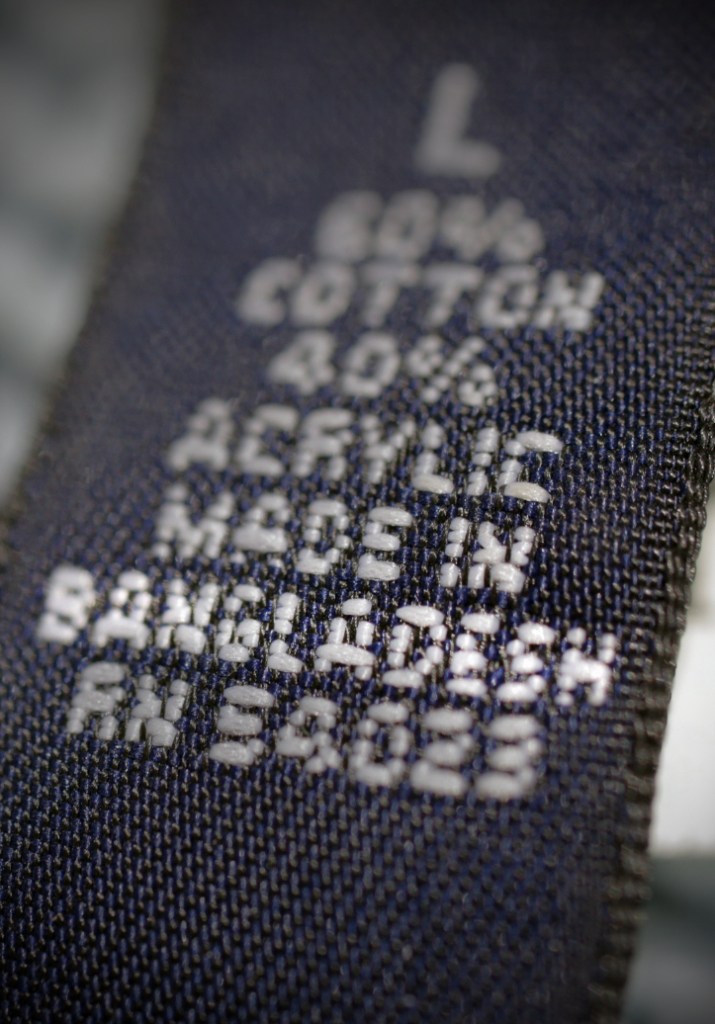 A label inside a cardigan sweater sold by a U.S. retailer informs consumers that the garment was made in Bangladesh.