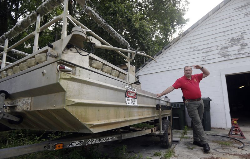 Morven Police Chief Lynwood Yates has acquired $4 million worth of military surplus over the past decade for his sleepy Georgia town of 700. Yates is standing next to one of three boats he bought.