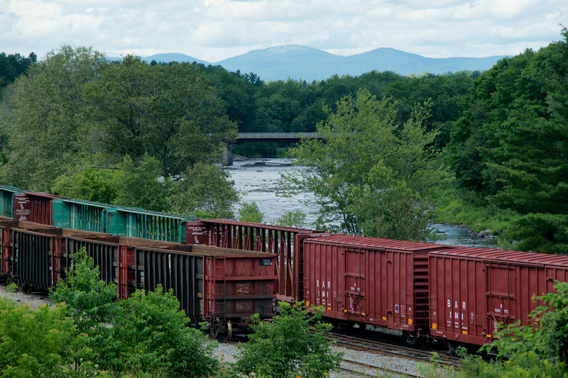 Boxcars owned by the Montreal, Maine & Atlantic Railway sit idle next to the Pleasant River in Brownville last Tuesday. The cars still carry the “BAR” markings of the Bangor and Aroostook Railroad, which operated between 1891 and 1995. A significant part of the company’s business was hauling potatoes from Aroostook County in heated boxcars.