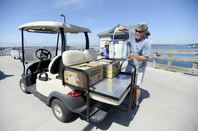 Wes Wolfertz of Long Island loads up his golf cart after making a trip to the mainland for supplies Thursday, August 1, 2013