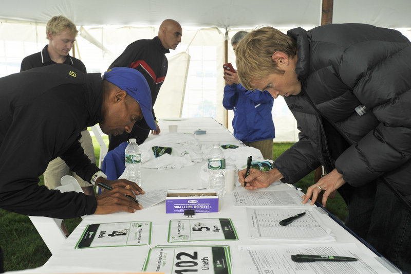 Ryan Hall, right, who didn’t arrive in Portland until 2 a.m. Friday, and Meb Keflezighi – perhaps the top two American males in the Beach to Beacon – register and collect their bib numbers in advance of Saturday’s race.