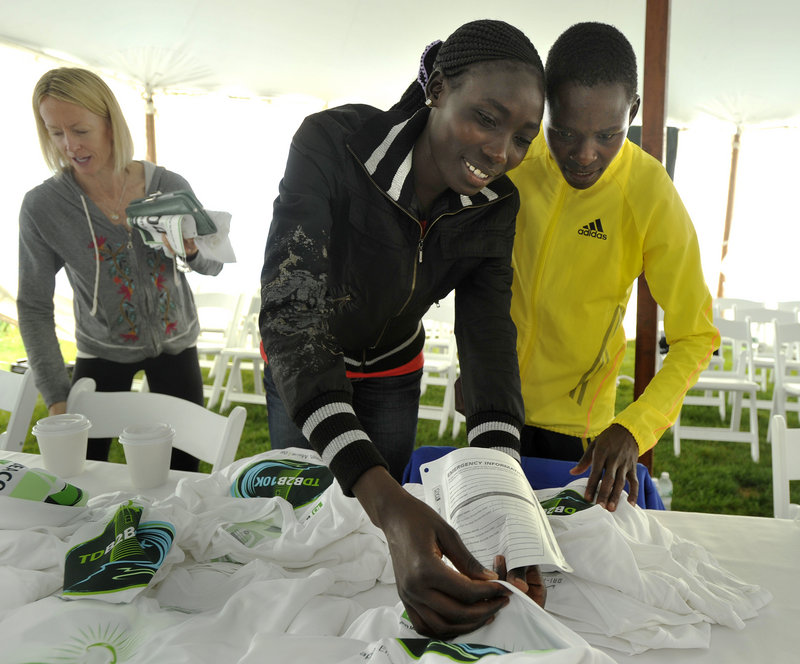 Looking over a selection of race T-shirts are three top female runners, left to right: Deena Kastor, Lineth Chepkurui and Joyce Chepkirui.