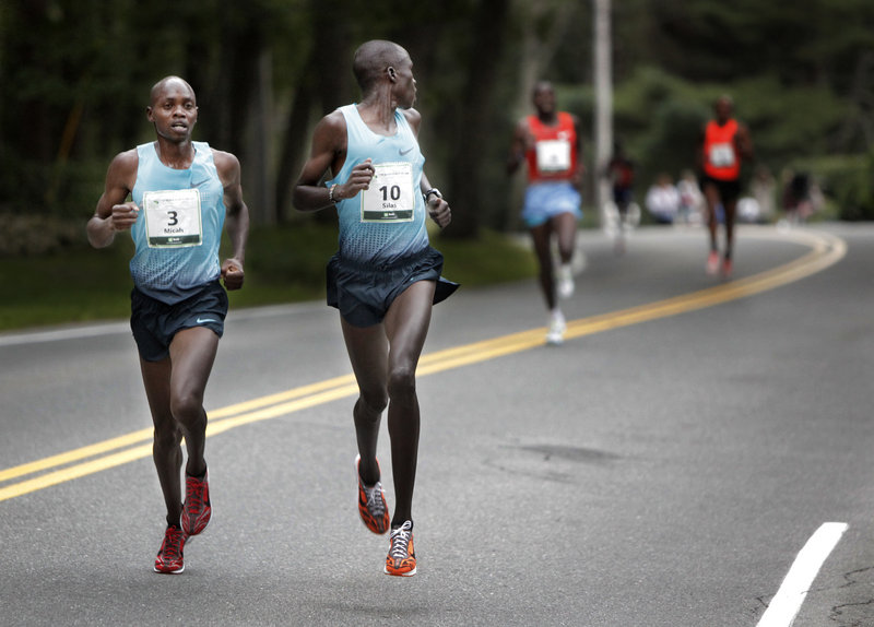 Silas Kipruto glances over his shoulder Saturday as he and the eventual race winner, Micah Kogo, set the pace early in the Beach to Beacon 10K in Cape Elizabeth.
