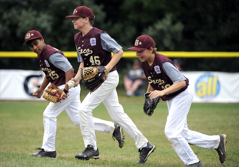 Ball caught, inning over and the Saco Little League players head to the dugout Saturday during the 12-1 victory against Newton, Mass., at the New England Little League Regionals at Bristol, Conn. From left to right are Anthony Bracamonte, Derek Madore and Andrew DeGeorge.