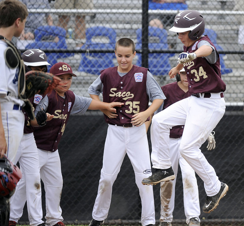 Brogan Searle-Belanger leaps on the plate Saturday after hitting a three-run homer in the third inning, giving Saco a 6-1 lead on the way to a 12-1 victory against Newton, Mass., at the Little League New England Regionals at Bristol, Conn. Searle-Belanger went 3 for 3, driving in four runs.