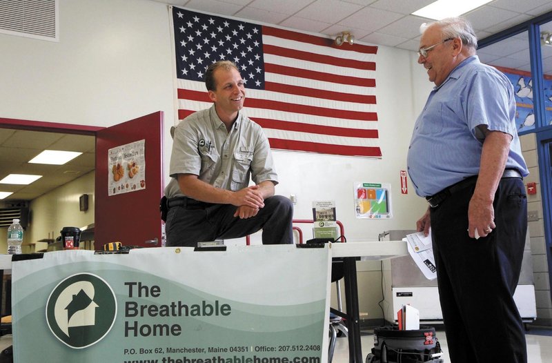 Bo Jespersen, owner of The Breathable Home, chats with a customer at a free Energy Expo at Madison Area Memorial High School on Saturday.