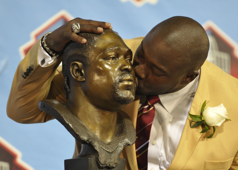 Former defensive lineman Warren Sapp shows his softer side as he kisses his own bust while being inducted in the Pro Football Hall of Fame in Canton, Ohio, on Saturday. Also inducted were Jonathan Ogden, Dave Robinson, Larry Allen, Bill Parcells, Curley Culp and Cris Carter.