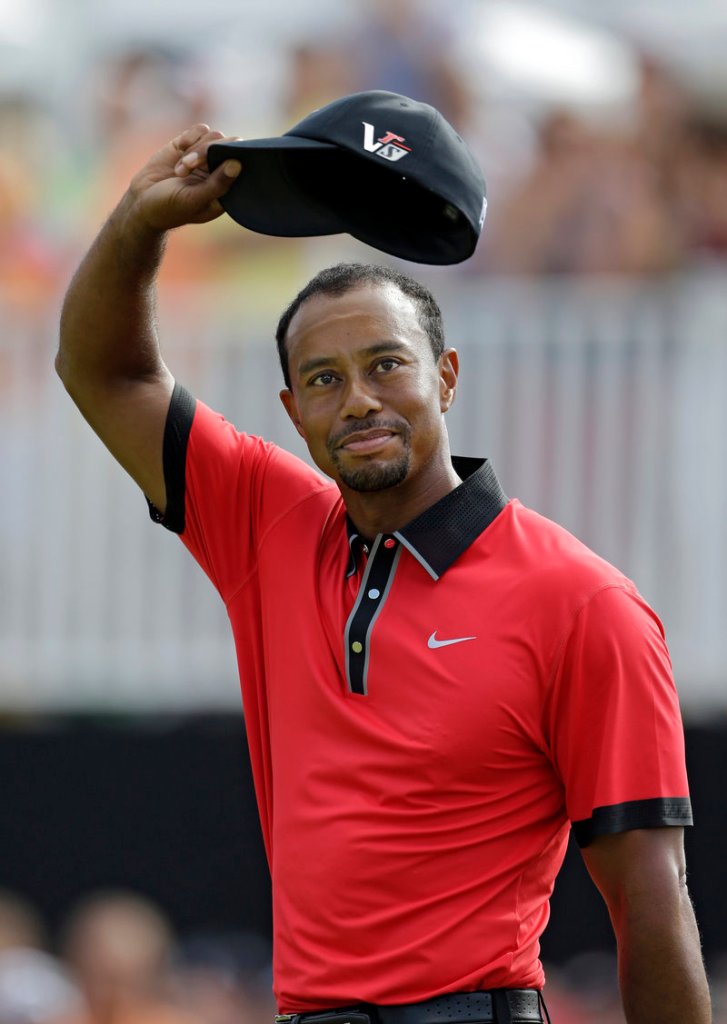 Tiger Woods waves on the 18th green of the Firestone Country Club in Akron, Ohio, after easily winning the Bridgestone Invitational on Sunday. Woods shot an even-par 70, beating defending champion Keegan Bradley and Henrik Stenson by seven shots.