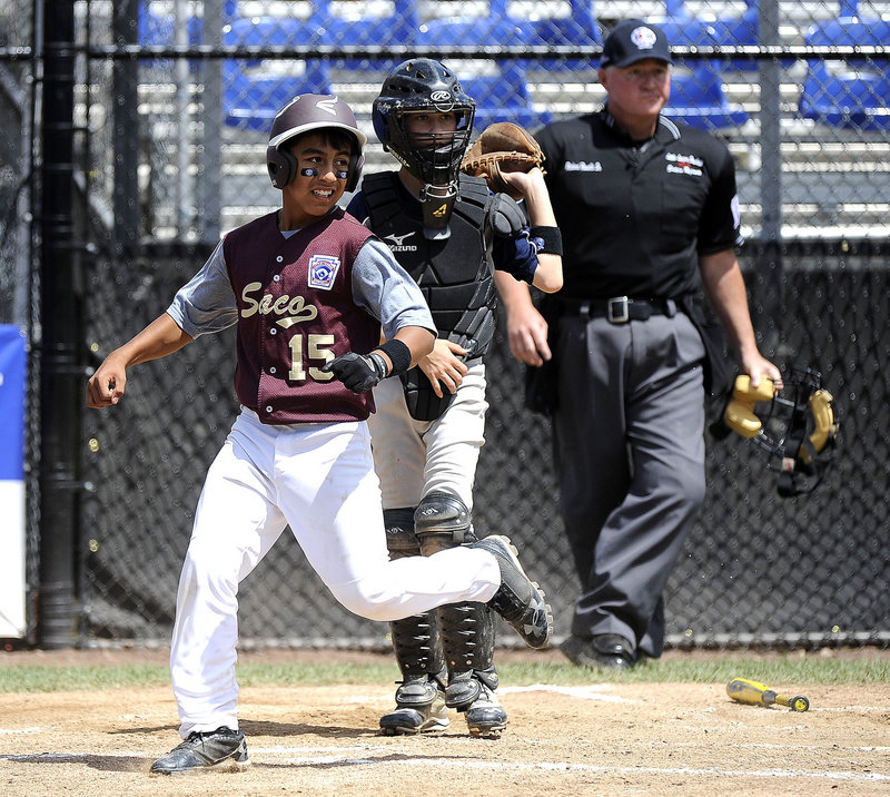 Anthony Bracamonte of Saco scores when a ball is misplayed Tuesday in the third inning of a 3-2 loss to South Burlington, Vt., at Bristol, Conn. Saco ended pool play with a 1-3 record but will advance if Massachusetts and New Hampshire lose Wednesday.