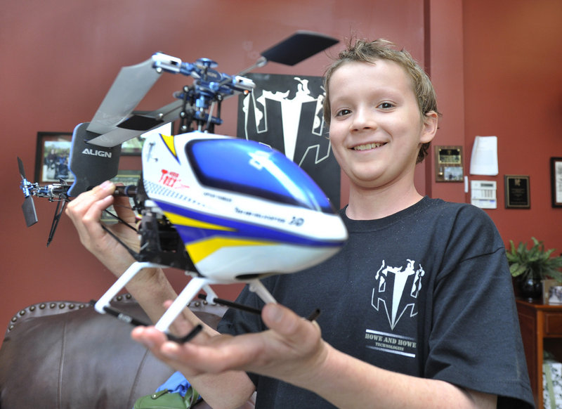 Florian Knollmann with the remote-control helicopter he helped to build at Howe & Howe Technologies in Waterboro.