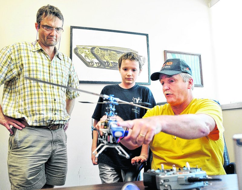 Burt Dumond, right, president of the Southern Maine Radio Control Helicopter Association, explains the workings of a helicopter Wednesday to Florian Knollmann, 12, and his dad, Bjorn, at Howe & Howe Technologies in Waterboro.