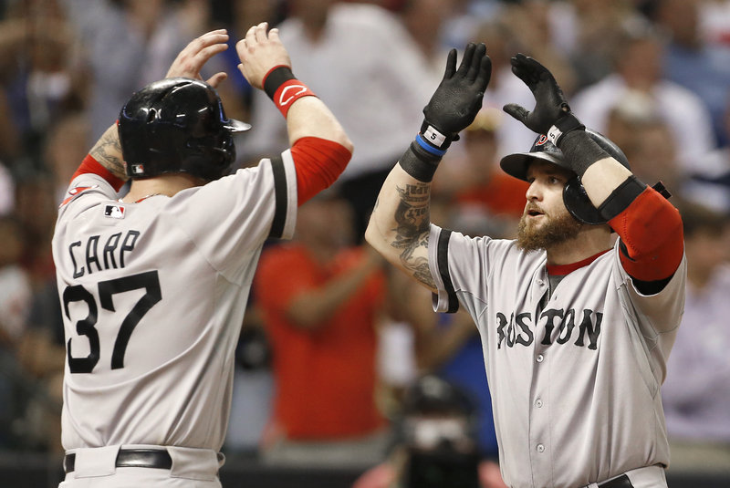 Jonny Gomes, right, is greeted at home by Mike Carp after hitting a two-run home run against the Houston Astros in the seventh inning Wednesday. Boston rallied for a 7-5 win.