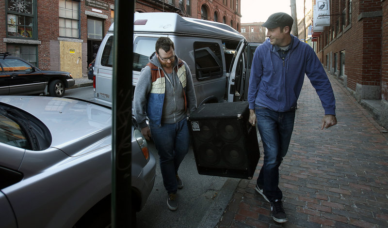 Bandmates Matt Cosby and Pete Kilpatrick lug equipment into the Market Street venue before the show. These days, musicians often struggle to be heard above all the competition.