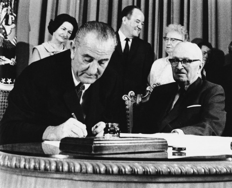 President Lyndon Johnson signs the Medicare bill into law July 30, 1965, as former President Harry Truman, right, observes at the Truman Library in Independence, Mo. A letter writer says the program is more cost-effective than private health insurance.
