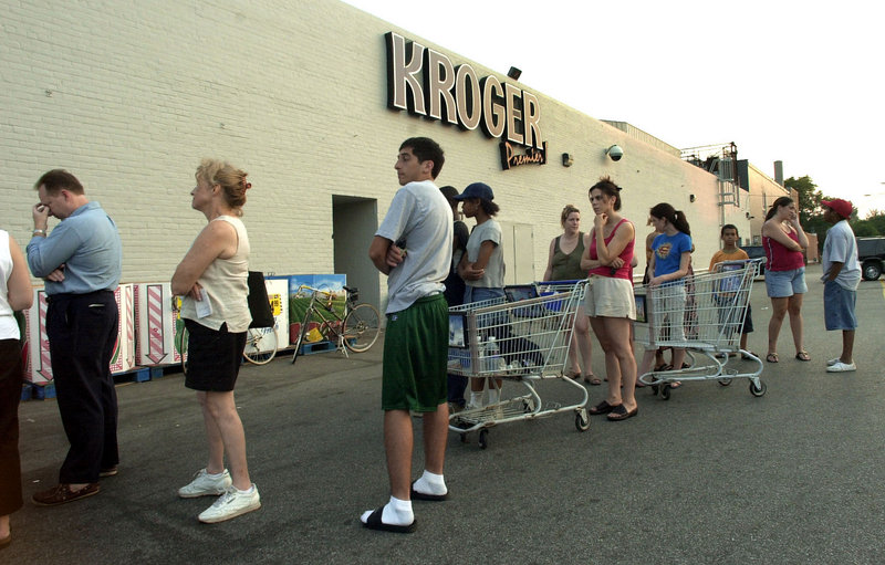 Customers wait in line to buy essential items at a grocery store in Grosse Pointe, Mich., after the blackout of August 2003.