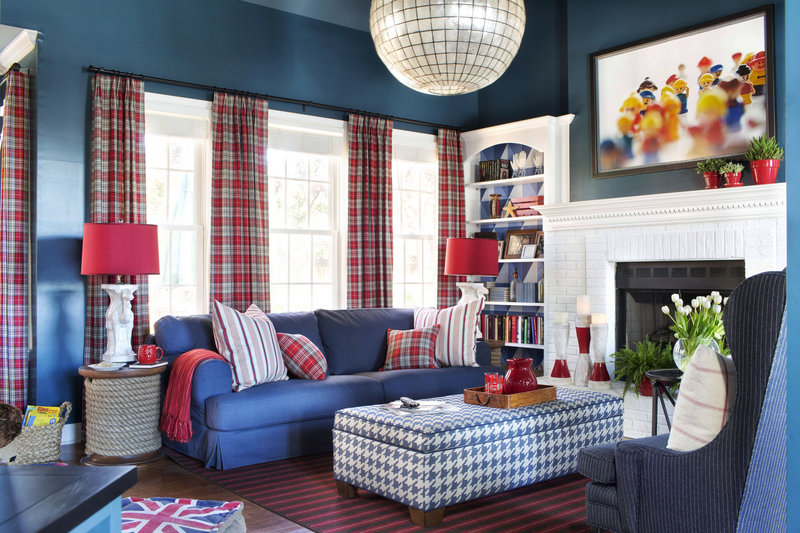 This playful family room uses youth in the decor, with original framed photography of 1980s Duplo figures and a vibrant palette of navy blue and fire engine red.