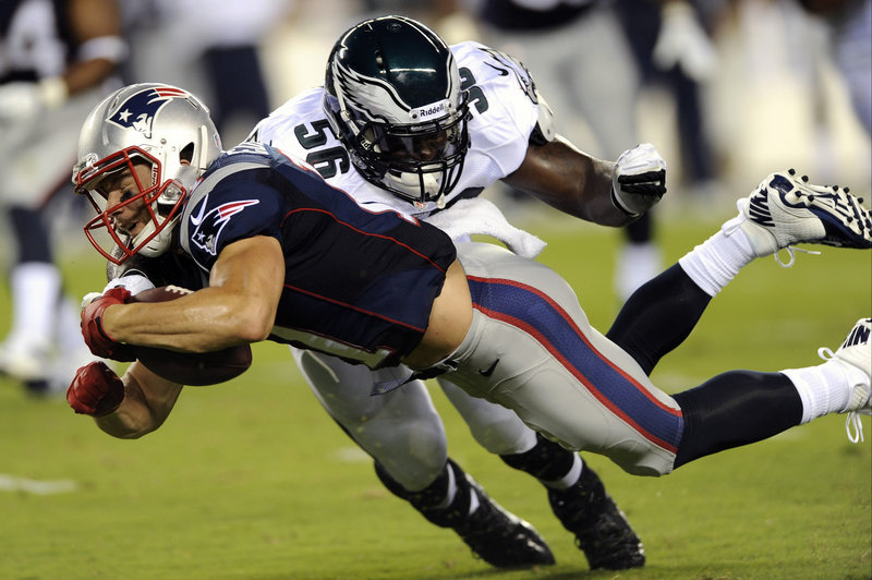 Julian Edelman of the Patriots dives for extra yardage after making a catch as Phillip Hunt of the Eagles brings him down. The Patriots won the opening exhibition game, 31-22.