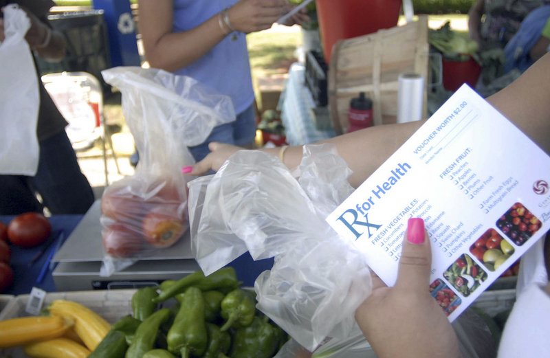 Nely Pagan of Norwich, Conn., uses vouchers from the William W. Backus Hospital to buy vegetables at the farmers market in downtown Norwich. “It’s very helpful,” she said. ‘We have a lot of fruit and vegetables at home.”