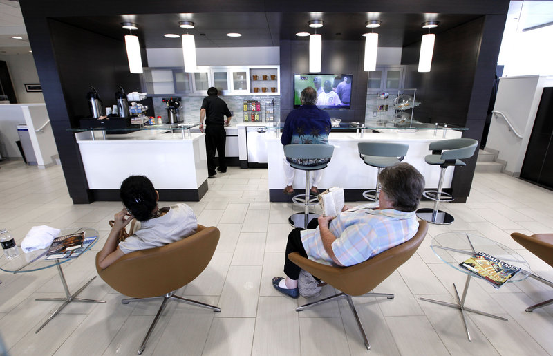Customers sit in the cafe area of Hines Park Lincoln, a dealership in Plymouth, Mich., that has been renovated to be more appealing to luxury buyers. The building is light and airy and has clusters of sumptuous leather seating.