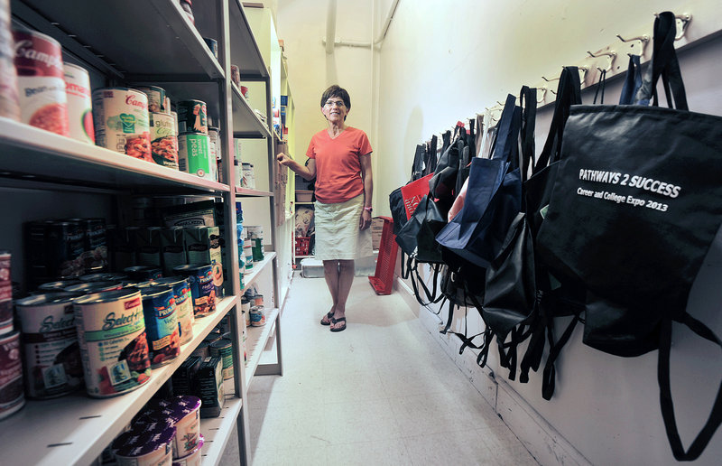Portland High School assistant principal Kathie Marquis-Girard stands in the school's food pantry, which provides food items for students in need. The backpacks on the right allow the students to carry the food items without attracting undue attention.