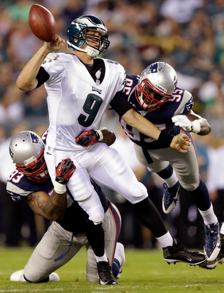 Tommy Kelly, left, combines with Chandler Jones to sack Eagles QB Nick Foles in Friday’s preseason game at Philadelphia. Kelly, who played nine years with the Raiders, is off to a good start in New England.